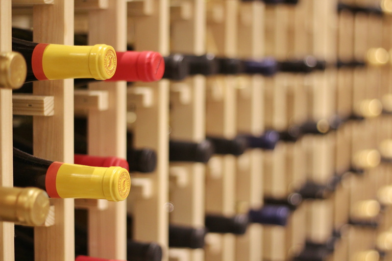 shelf, bottle, red wine, wine rack, rack, indoors, boston public market, in a row, drink, yellow, red, collection, alcohol, market, container, storage compartment