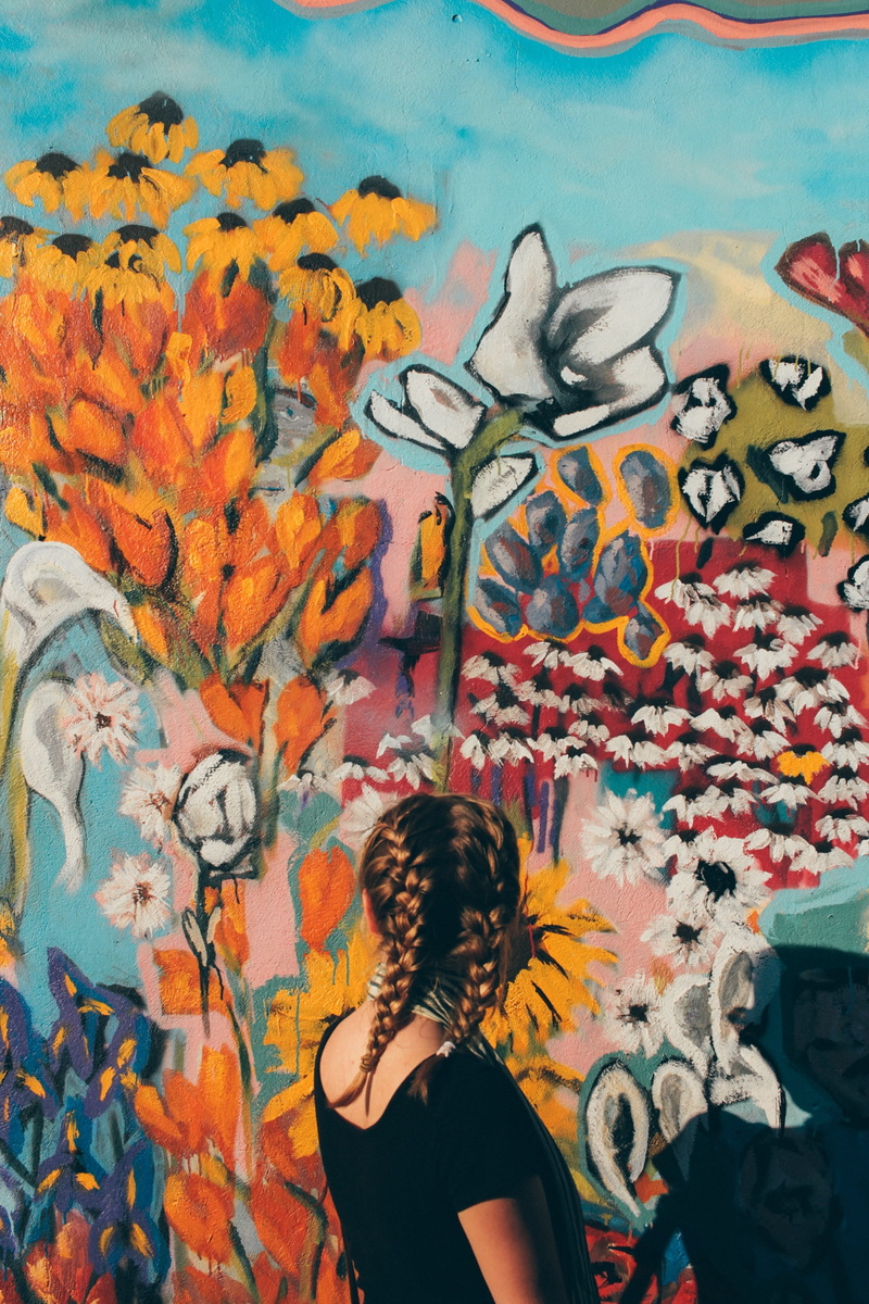 1080P, one woman only, shadow, woman, built structure, real people, hairstyle, flowers, women, wall, painted image, scarf, back, looking, floral pattern