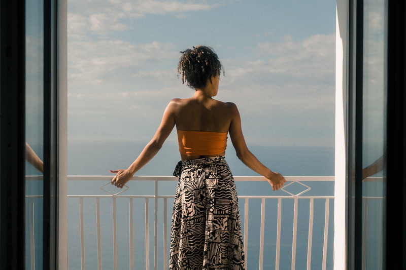 looking at view, adult, young women, sunlight, sunset, clothing, back, standing, black, african american, woman, sunny, behind, balcony, dress, women, sky