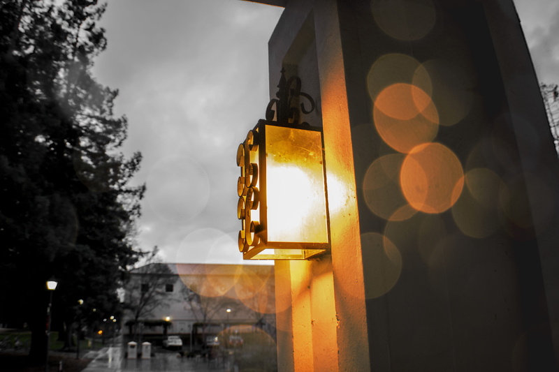 wet, lighting equipment, 5K, street light, yellow, street, dusk, santa clara university, outdoors, transparent, clouds, city, focus on foreground, lens flare