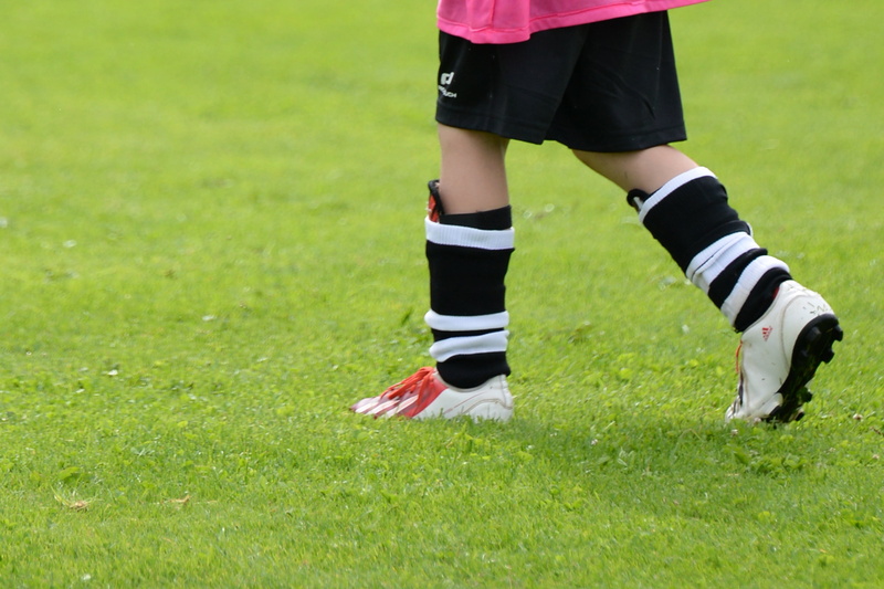 football boots, body part, soccer ball, human leg, award, youth department, daytime, outdoors, cohesion, youth, nature, football, human body part, cup