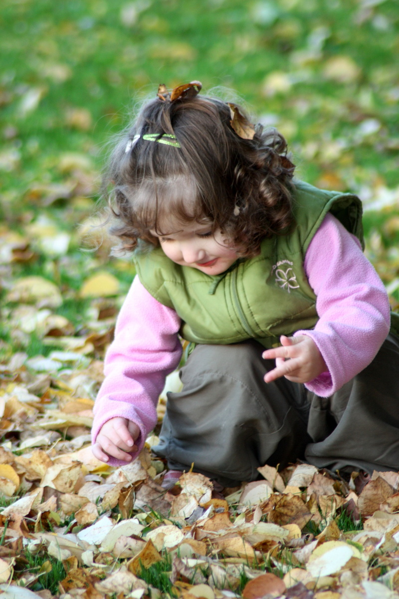 in the, females, victory sign, plant part, smile, leaf, innocence, hair, nature, lure, leaves, happy, colorful, childhood, real people, child, girl, forest