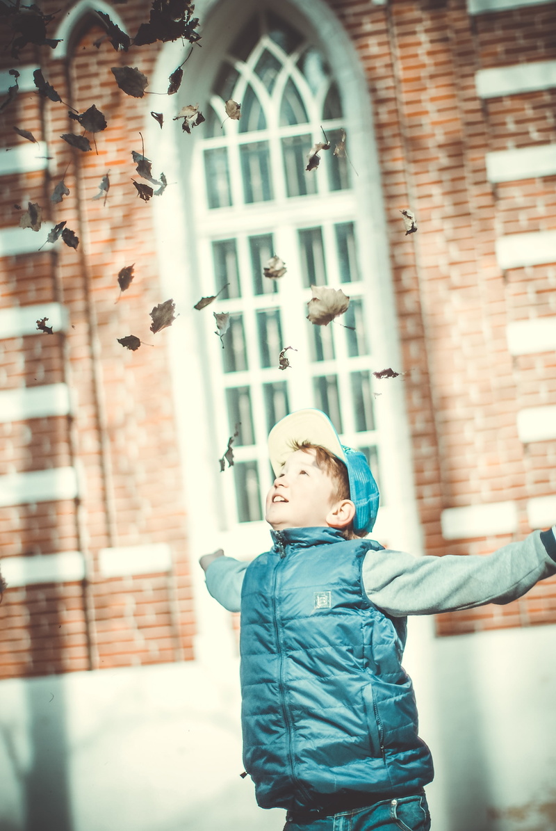 smile, leaves, one person, day, child, innocence, males, air, real people, beautiful, looking, sun, boys, boy, throwing, vest, built structure, wearing