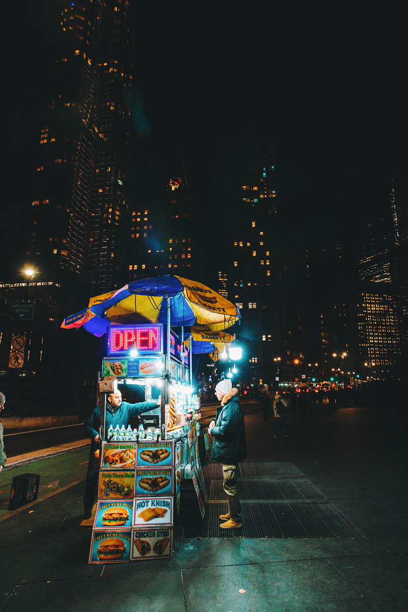 architecture, protection, cityscape, cart, real people, people, standing, street, city life, food, business, hotdog, front, outdoors, 5K, leisure activity