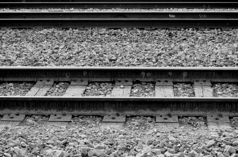 tracks, outdoors, stone - object, metal, 2K, day, rail, stone, side by side, high angle view, rock, rail transportation, railroad track, gravel, black and white
