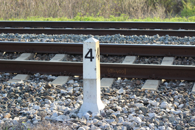 rail transportation, stone, sunlight, railroad track, no people, public transportation, sign, nature, day, railroad tie, transportation, rock, stone - object