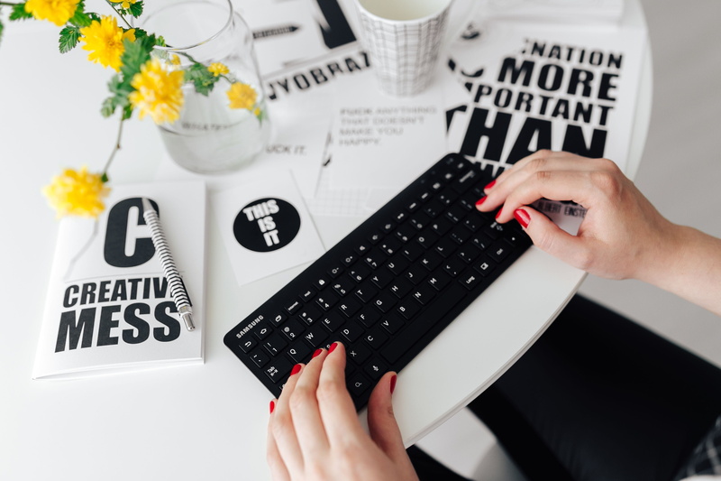 writing, hand, computer keyboard, human body part, text, table, female office, high angle view, remote, typing, workplace, communication, flower, minimalist
