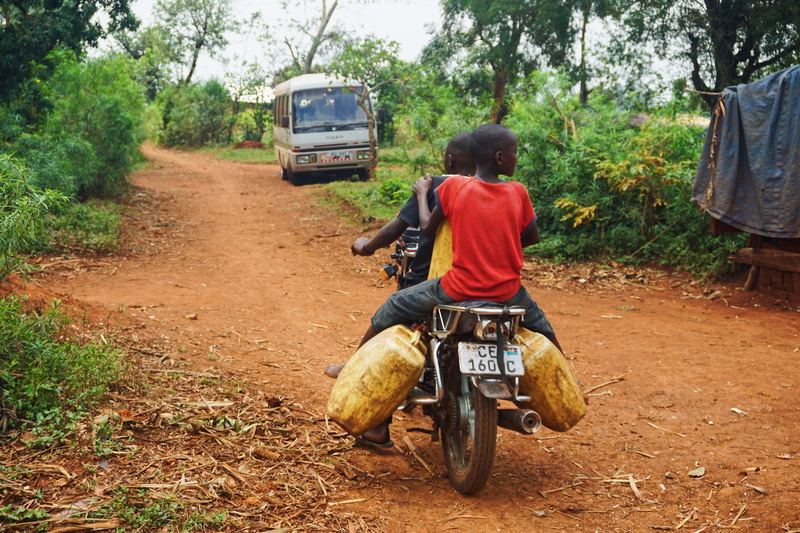 one person, field, mode of transportation, motorcycle, jungle, dirt road, vespa, leisure activity, tree, human, nature, land vehicle, riding, 5K, rear view