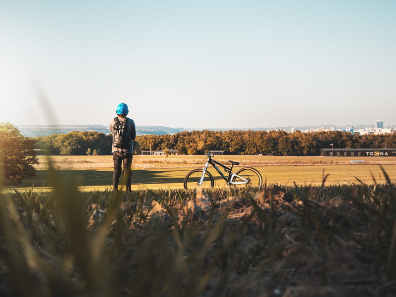 headwear, sunlight, czechia, road, land vehicle, sky, lifestyles, mountain bike, grass, outdoors, grassland, soil, transportation, flora, 4K, gravel, vehicle