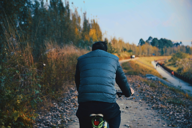 person, lifestyles, gravel, land, casual clothing, 5K, bicycle, human, environment, road, tarmac, vehicle, rear view, outdoors, one person, apparel, tire