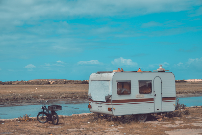blue, truck, bike, mode of transportation, landscape, non-urban scene, dirt road, stationary, caravan, rv, cloud - sky, outdoors, field, ground, day, no people