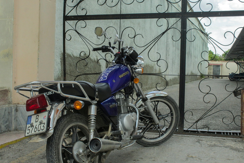 stationary, dirt road, engine, wheel, building exterior, camaguey, path, outdoors, city, motor scooter, architecture, alloy wheel, transportation, cuba