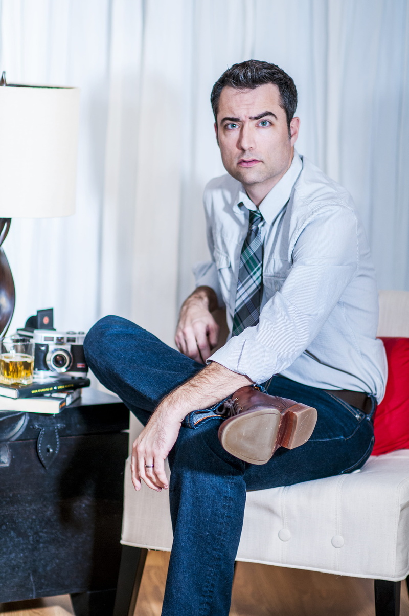 front view, person, bright, legged, looking at camera, film camera, men, business, business person, cross, mid adult, sitting, sofa, guy, serious, whiskey
