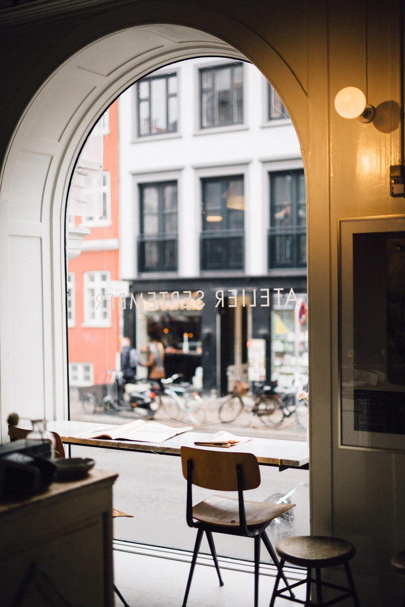 white, restaurant, outdoors, daytime, city, round, setting, building exterior, no people, stool, seat, light, architecture, focus on foreground, chair