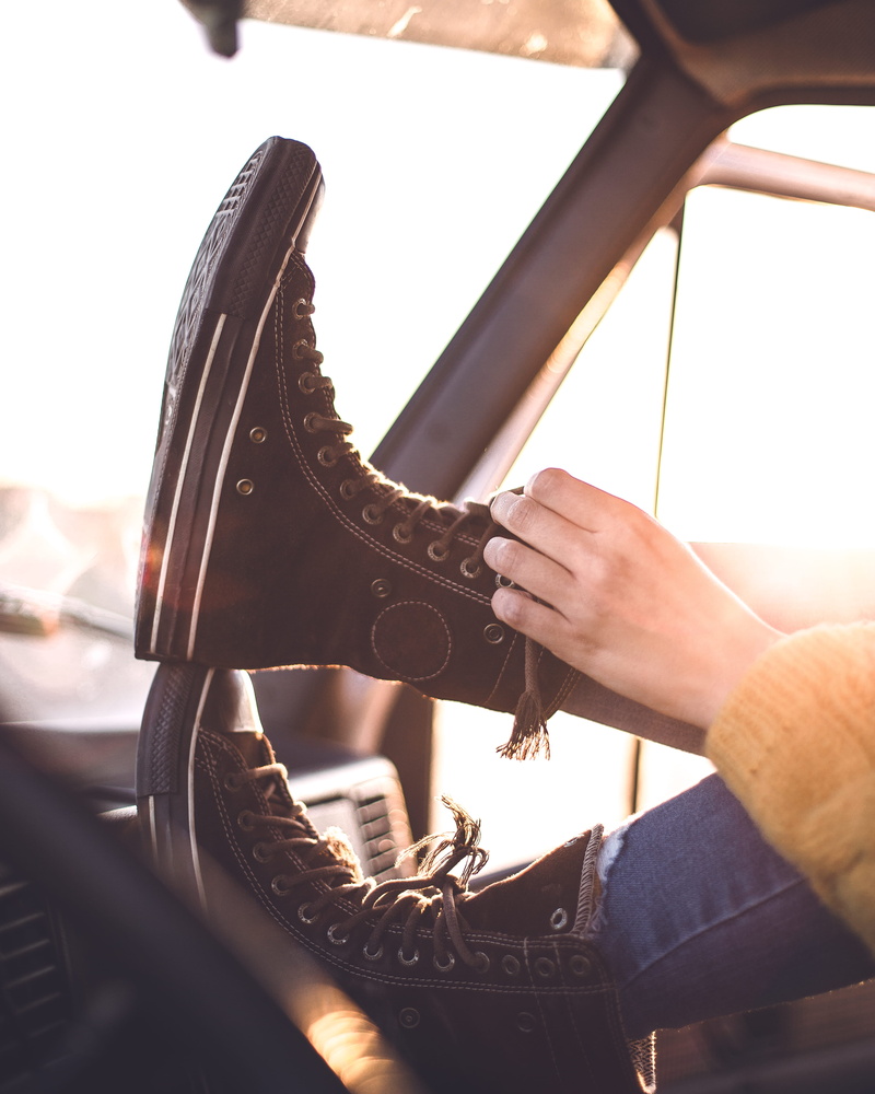 machine, finger, tying, occupation, apparel, shoelaces, nature, metal, spoke, human, sunlight, footwear, holding, converse, clothing, high heel, human body part