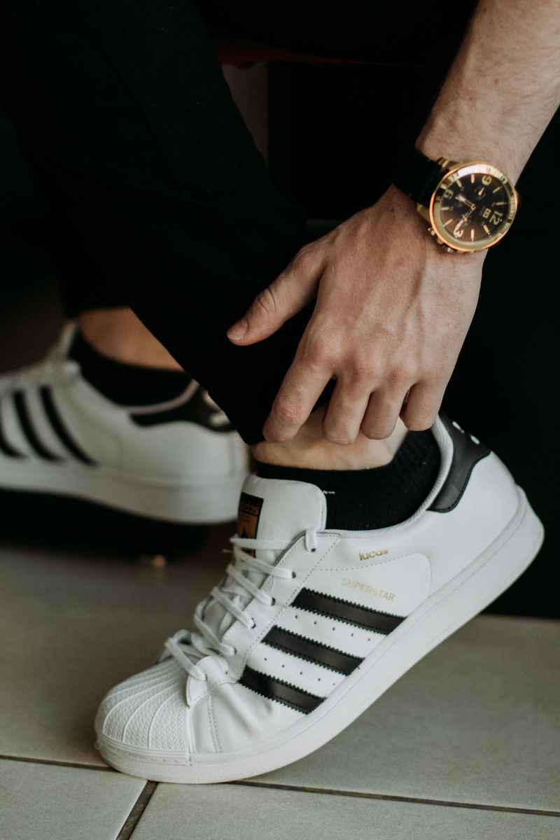 hand, one person, depth of field, wearing, human hand, person, adidas, footwear, men, 5K, indoors, sneakers, focus, floor, superstar, human body part