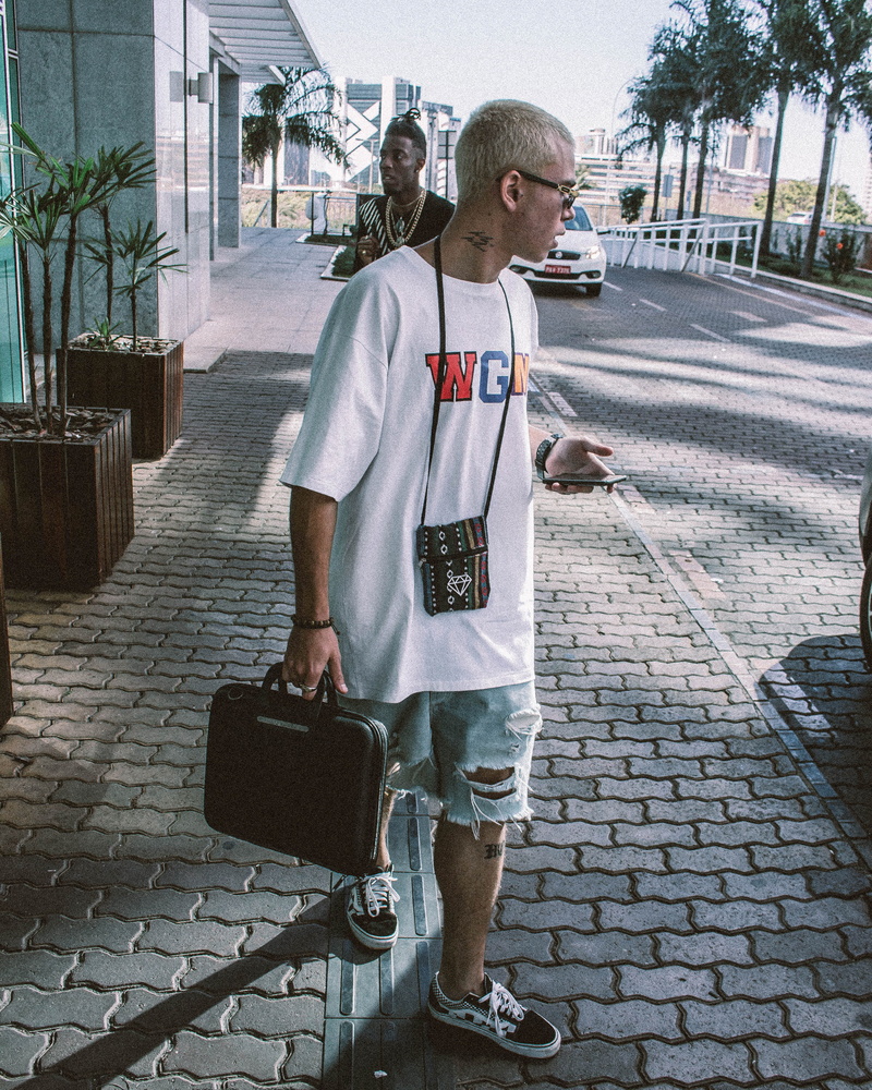 casual clothing, side view, outdoors, man, uniform, leisure activity, real people, t-shirt, young adult, holding, white, person, day, city, building exterior
