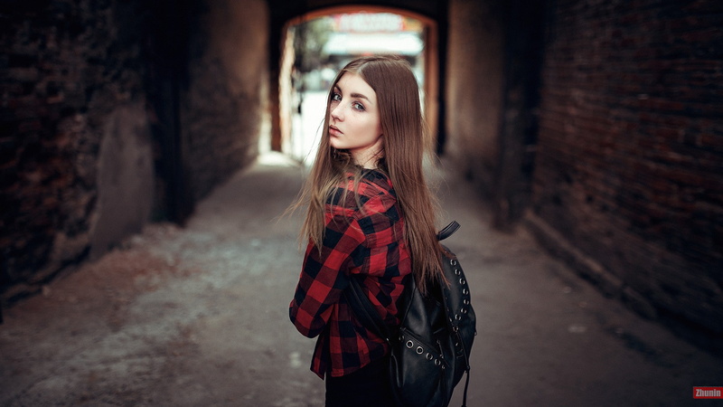 looking over shoulder, architecture, emotion, shirt, looking back, plaid shirt, outdoors, portrait, beautiful woman, backpacks, looking, hairstyle, beauty