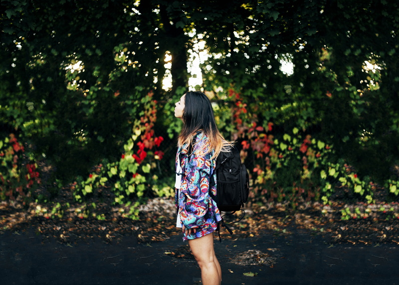green, real people, young women, long hair, sunlight, model, three quarter length, near, ombre, rear view, backpack, hairstyle, floral pattern, trees, one person