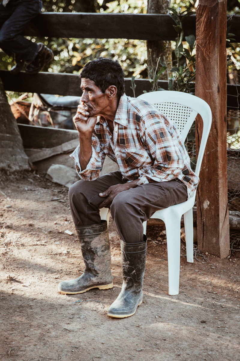 clothing, nature, cowboy boot, man, seat, young men, real people, mature men, person, hat, full length, human, sitting, cowboy hat, building, chair, face