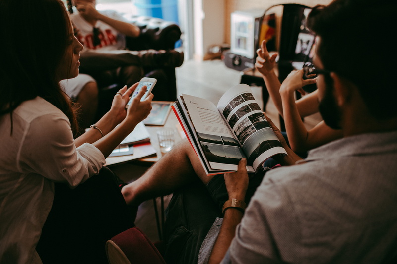 communication, real people, chair, woman, telephone, mobile phone, conversation, magazine, adult, group of people, sit, men, selective focus, group, room
