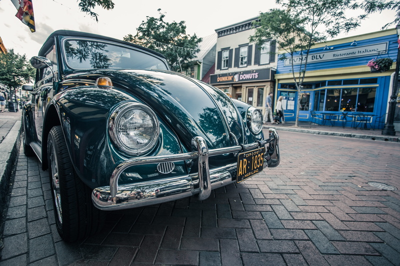 building exterior, shiny, transportation system, outdoors, reflection, day, coupe, incidental people, asphalt, city, land vehicle, Annapolis, paving stone