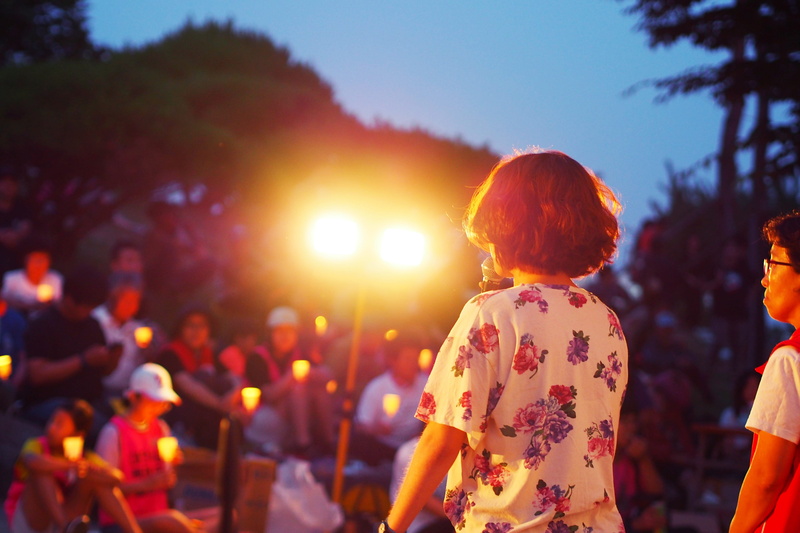person, three quarter length, rear view, focus on foreground, hair, incidental people, adult, childhood, sunlight, audience, speak, light, sky, plant, daughter