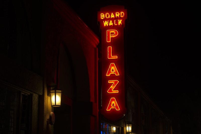 board walk, architecture, illuminated, street scape, building exterior, light - natural phenomenon, plaza, dark, no people, street, low angle view, western script
