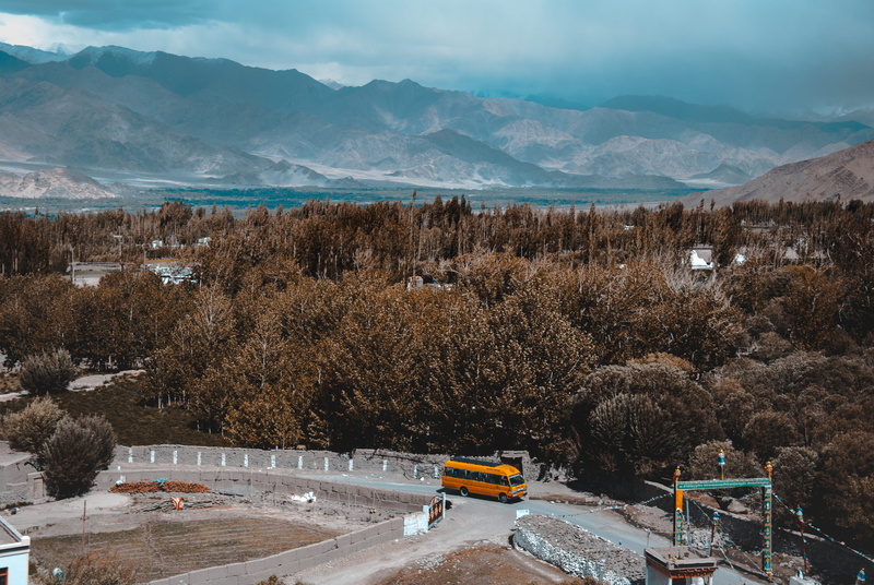 cold temperature, day, plant, nature, vibe, land vehicle, motor vehicle, mountain range, sky, forest, bus, smooth, snow, mode of transportation, no people