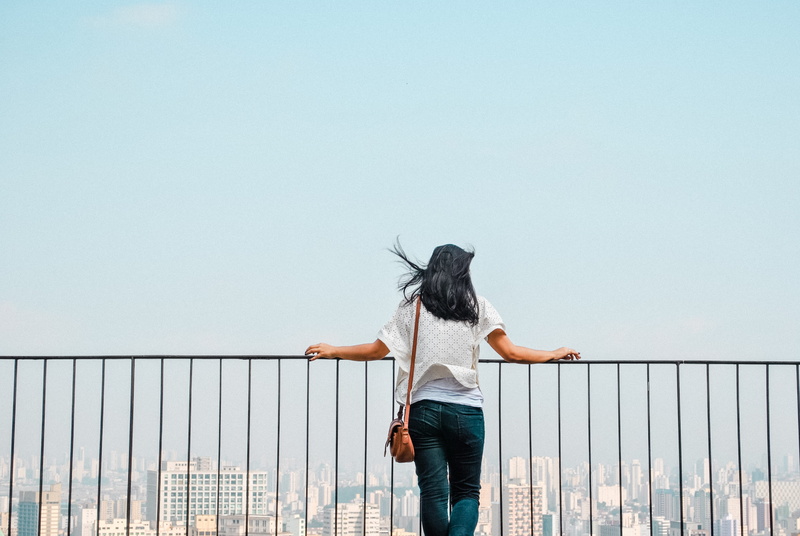 rear view, building, railing, bevedere, roof, standing, clear sky, real people, bridge - man made structure, holding, women, top view, rooftop, view, day