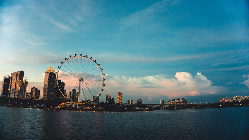 amusement park ride, singapore flyer, built structure, outdoors, skyscraper, urban skyline, office building exterior, no people, wheel, city, sky, building exterior