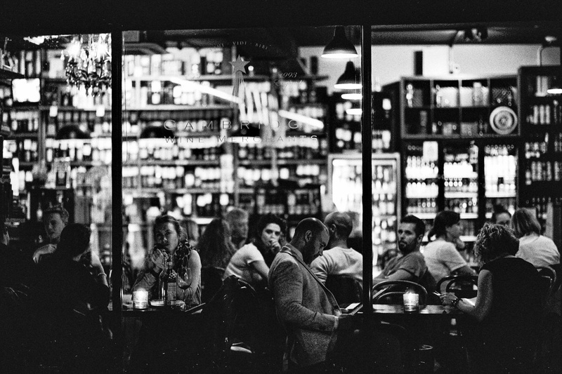outside, illumianted, men, city life, people, building exterior, crowd, grayscale, black and white, street, leisure activity, photography, store, seating aria