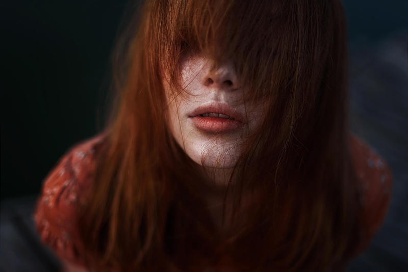 black background, bangs, face, body part, beauty, hair in face, long hair, dyed red hair, one person, 2K, close-up, front view, women, young adult, hairstyle