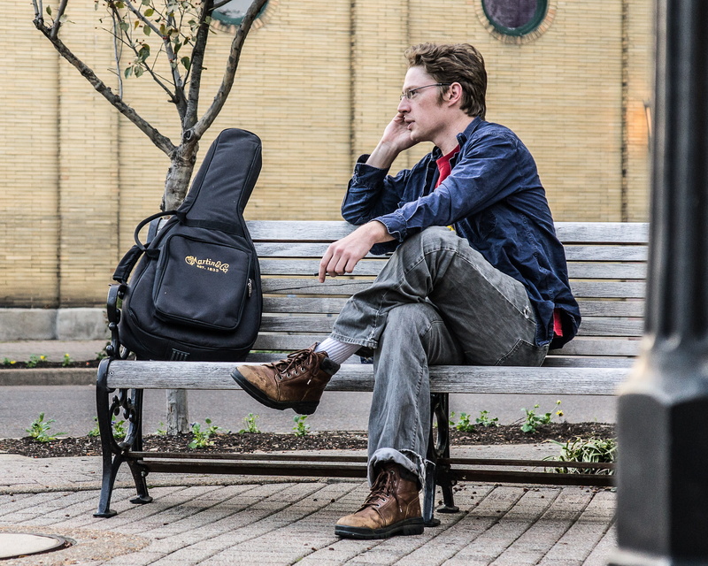 adult, front view, leather jacket, 2K, outdoors, bench, young men, lifestyles, paducah historic riverfront, sitting, full length, young adult, casual clothing