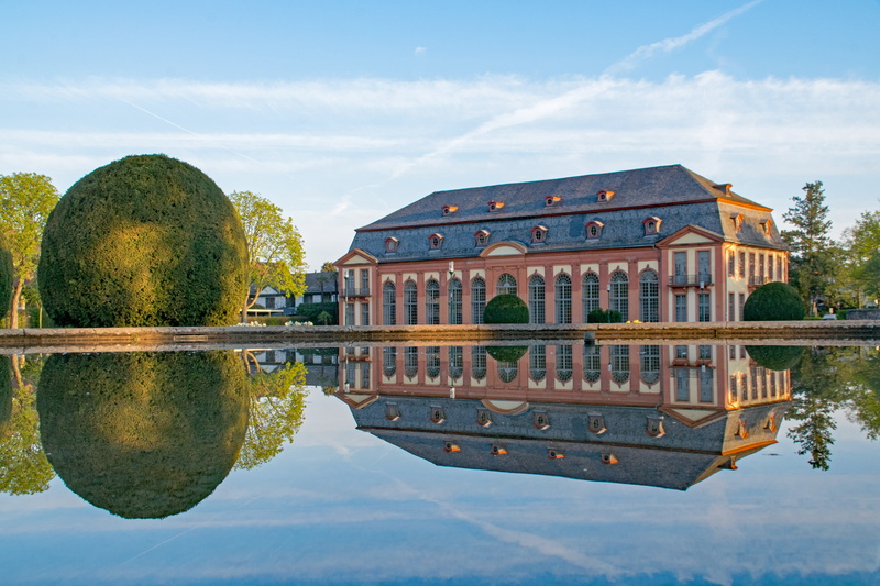 residential district, lake, topiary, building exterior, symmetry, places of interest, outdoors, architecture, near, reflection, castle, red, plant, history