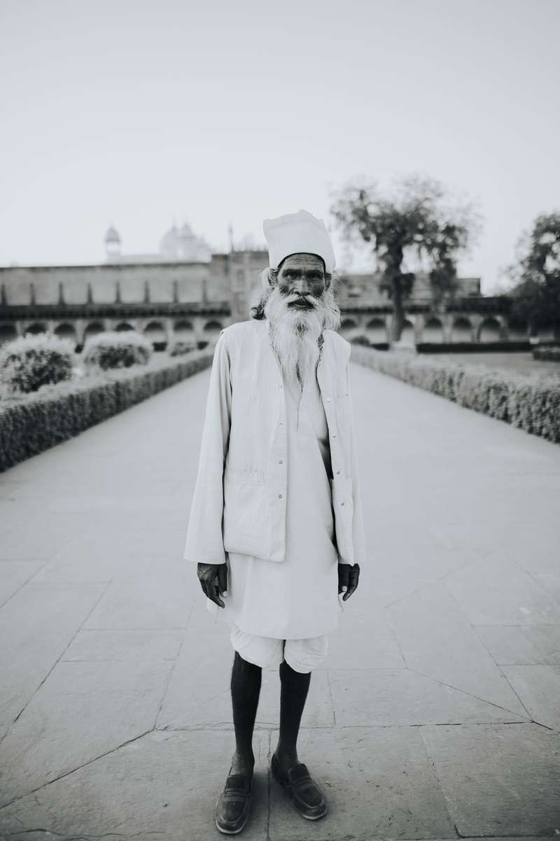 lifestyles, outdoors, street, indian man, culture, stand, pathway, grayscale, old man, outdoos, looking at camera, young adult, portrait, leisure activity