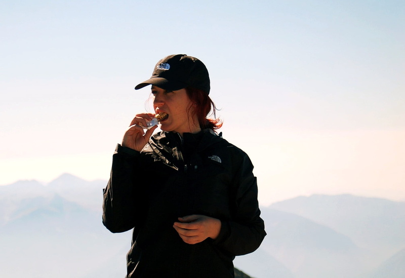 top, waist up, rest, real people, black, eating, girl, casual clothing, one Person, hiking, one woman only, clear sky, mountain, lifestyles, adult, clothing