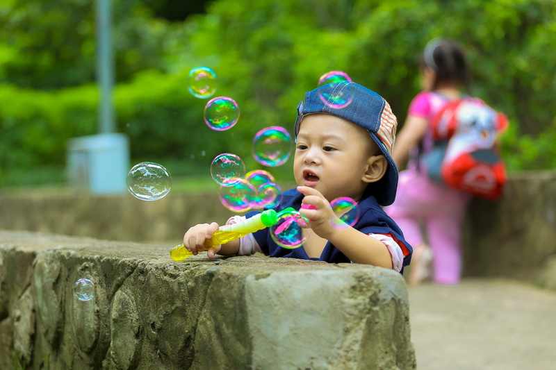 males, bubble, leaning, childhood, wall, daytime, play, people, cap, men, child, concrete, girls, fun, soap sud, holding, fragility, playing, blue, cute