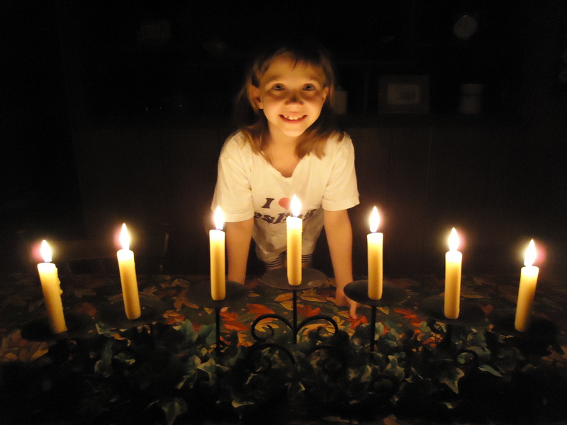 front view, standing, one person, black background, lit, passover, tradition, candles, happiness, life, fire, offspring, flame, girl, portrait, feast, light