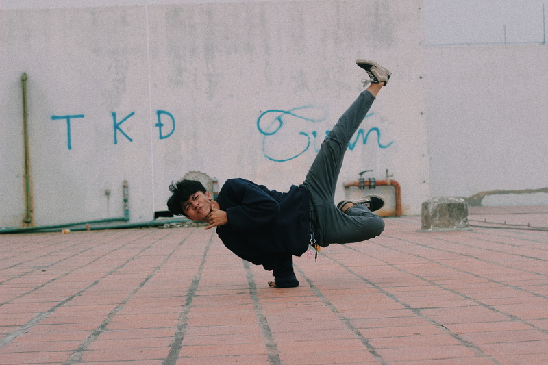young adult, kicking, handstand, dance pose, 5K, clothing, stand, leisure activities, real people, dancing, martial arts, building exterior, human, casual clothing