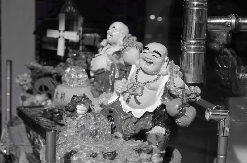 male likeness, indoors, sculpture, store, happy, deity, spirituality, art and craft, belief, focus on foreground, built structure, statue, religion, smiling
