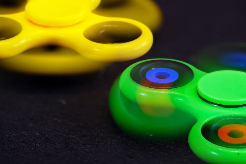 still life, indoors, fidget spinner, group of objects, plastic, play, green color, selective focus, backgrounds, focus on foreground, trend, toy, children