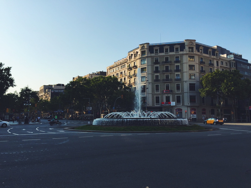 architecture, fountain, motion, car, vehicles, road, sky, roundabout, city, no people, built structure, street, urban, building, land vehicle, cars, urban Scene
