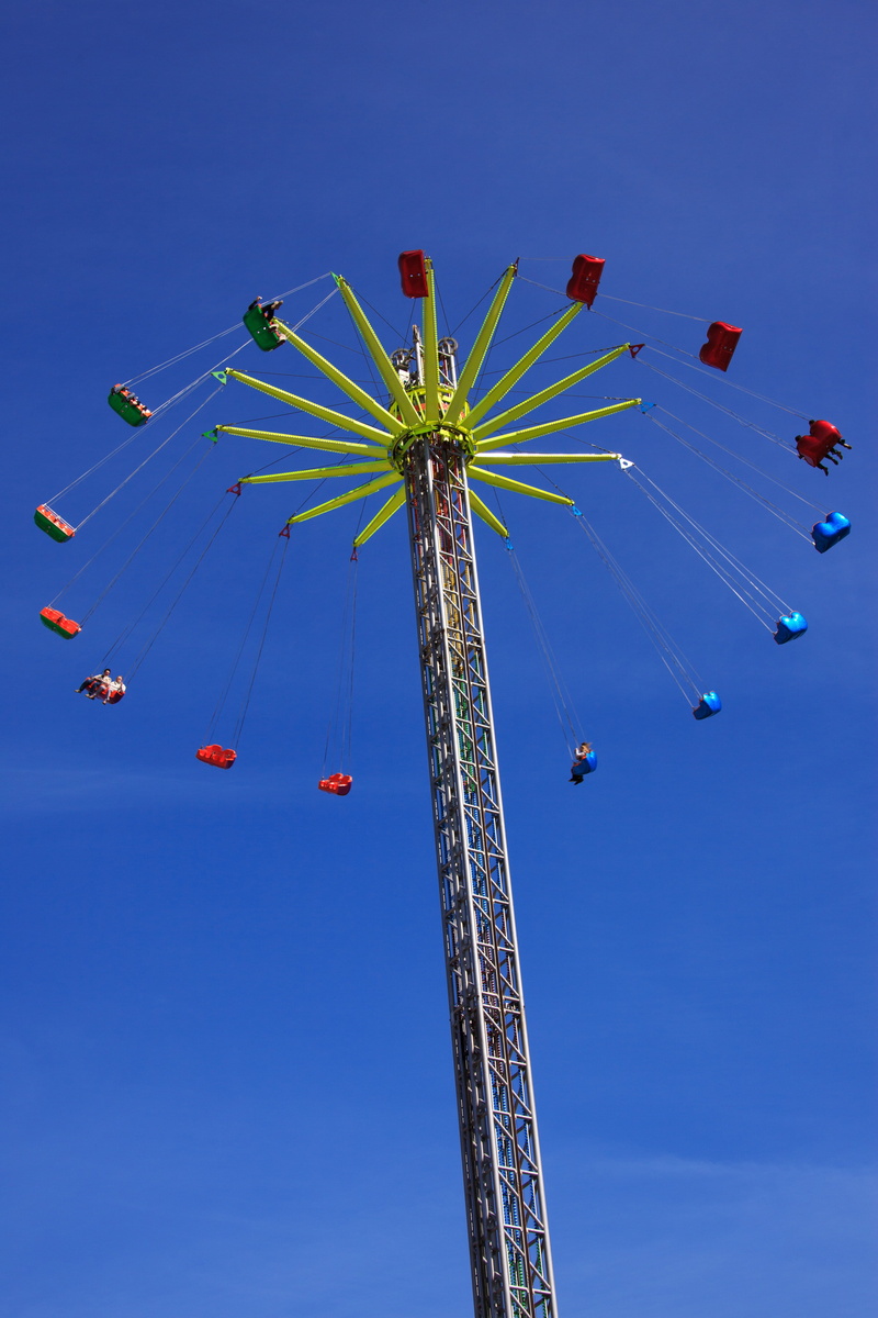 blue, clear sky, motion, outdoors, tall - high, low angle view, amusement, carousel, air, ride, summer, fly, funfair, incidental people, park, chains, leisure activity