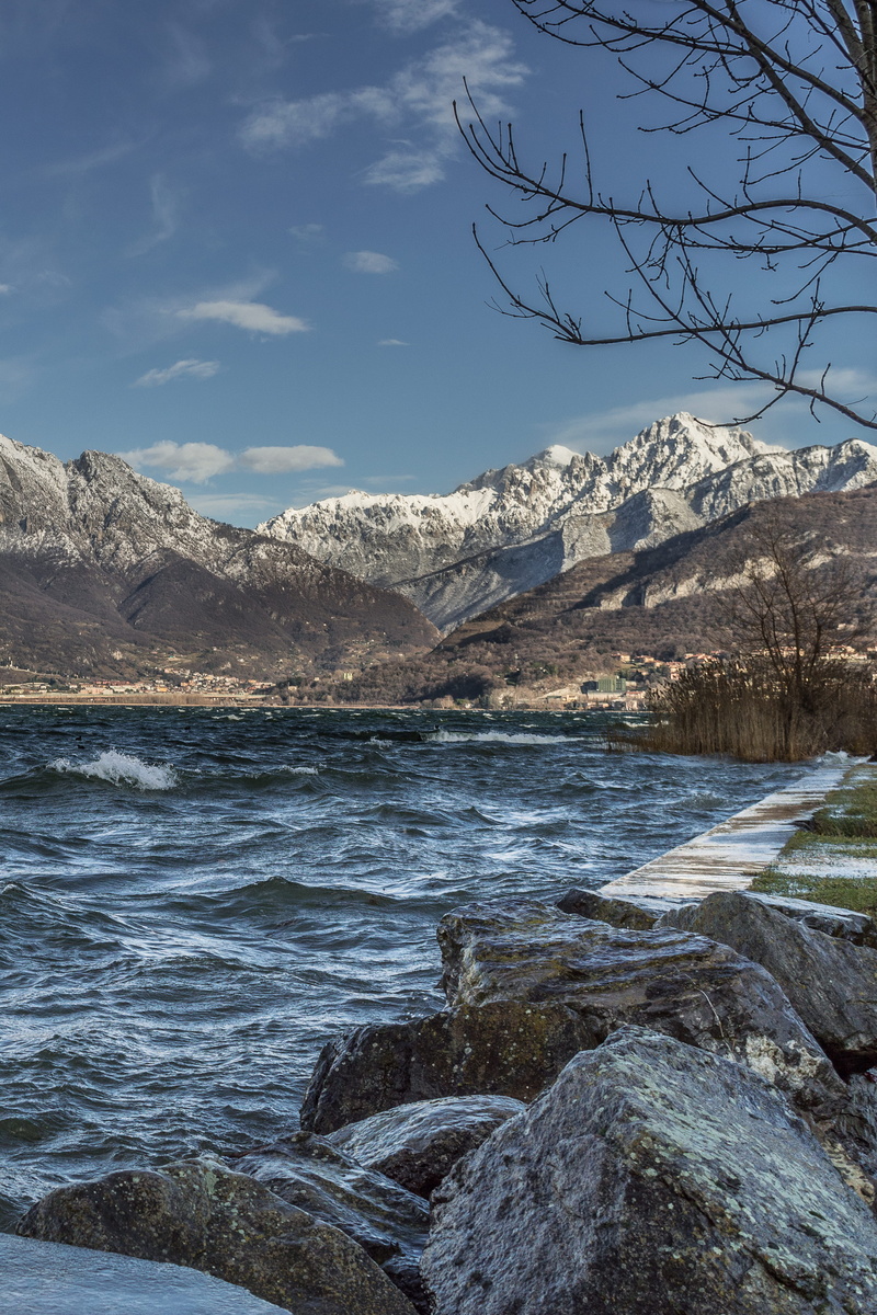 tranquility, beauty in nature, lecco, cloud - sky, water, annone, ice, tree, sky, outdoors, lake, lago di annone, promontory, mountain, day, stormy, environment
