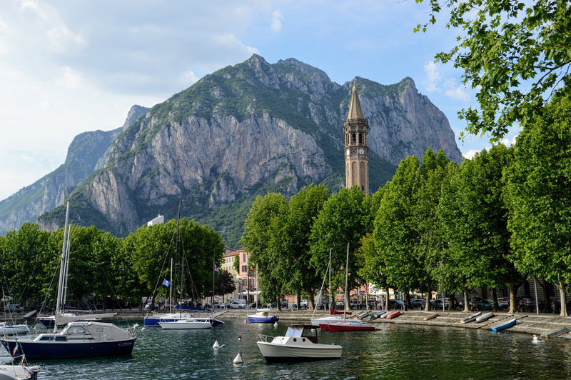 lake, travel destinations, mountain, water, nature, mountain range, incidental people, lombardy, built structure, transportation, waterfront, tree, italy