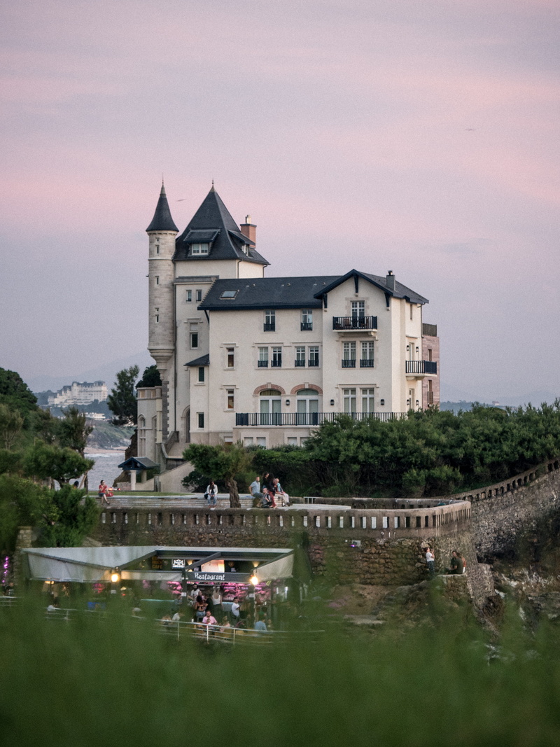 building exterior, waterfront, outdoors, biarritz, lake, sky, city, water, sunset, france, building, nature, tree, built structure, basque country, incidental people