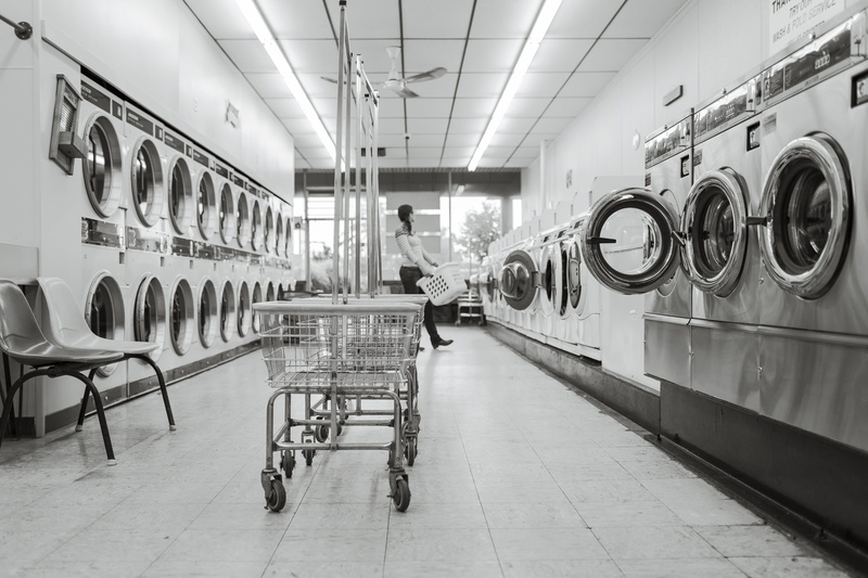 clothing, woman, grayscale, laundromat, towards, carrying, household equipment, photo, wash, indoors, 5K, housework, laundry saloon, domestic, carts, washing