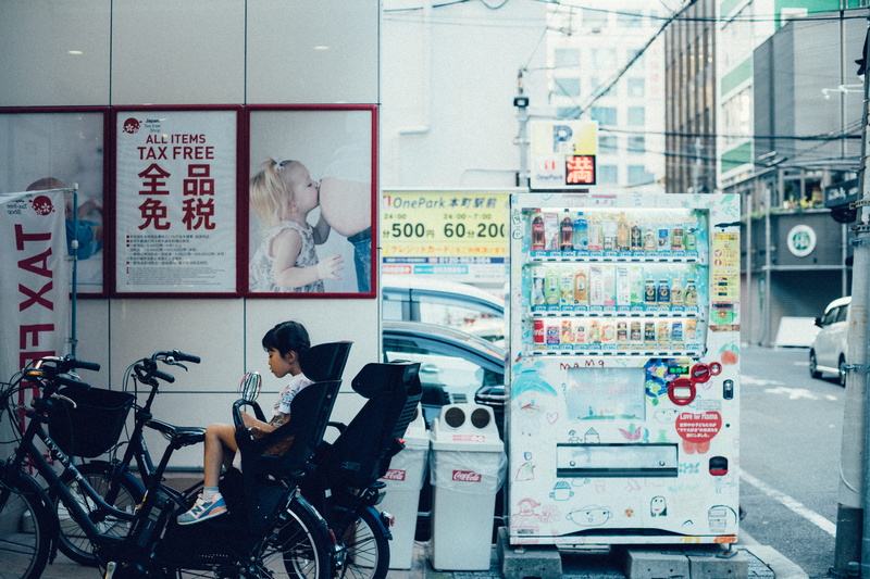 poster, transportation, working, trolley, stroller, vending machine, street view, concentration, adult, people, bicycle, add, occupation, child seat, children