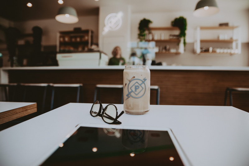 table, beside, person, latte, interior design, wood, cup, black, absence, home interior, coffee cup, beverage, lighting equipment, food and drink, desk